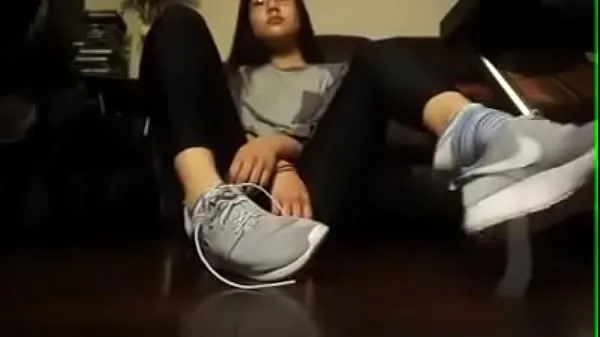 عرض Asian girl takes off her tennis shoes and socks قصاصات جديدة